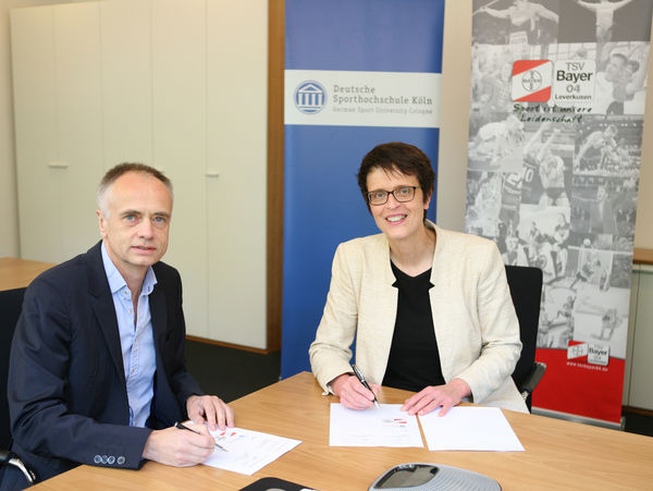 Univ.-Prof. Dr. Heiko Strüder, Rektor der DSHS Köln, und Anne Wingchen, Geschäftsführerin des TSV Bayer 04 Leverkusen, freuen sich auf die besiegelte Kooperation. Foto: DSHS Köln